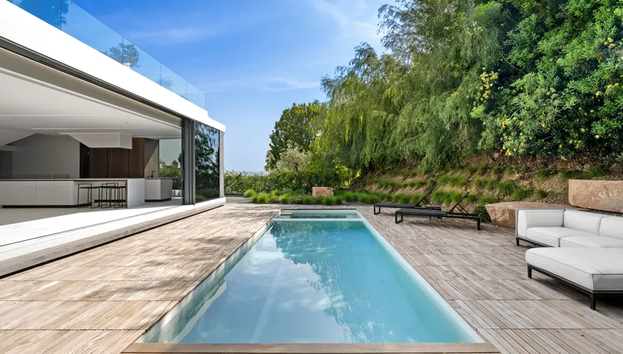 Lap pool beside a modern home and garden